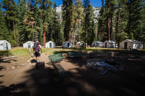 Walking into camp past the campfire circle in the morning sun.