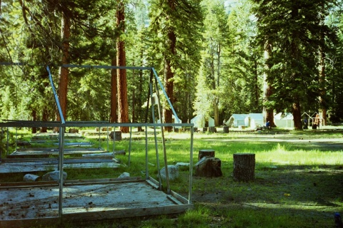 Rows of empty tent frames on the meadow before the canvas goes on.