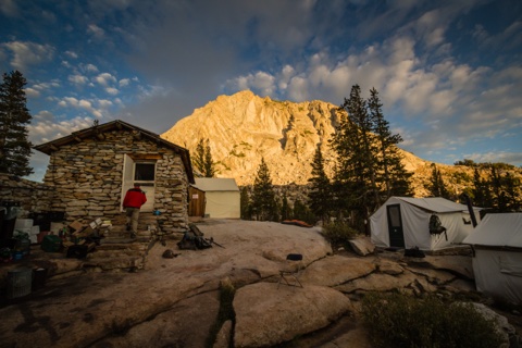 The stone building and tent cabins beneath Fletcher Peak at sundown.